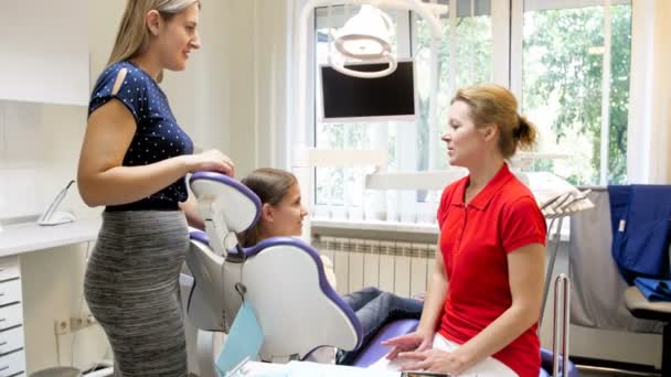 Filmagem 4k de mãe com filha conversando com dentista na clínica odontológica — Vídeo de Stock