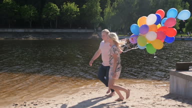 Mutlu çiftin renkli balonlar büyük grup ile gölün yanında çalışan Slow motion video