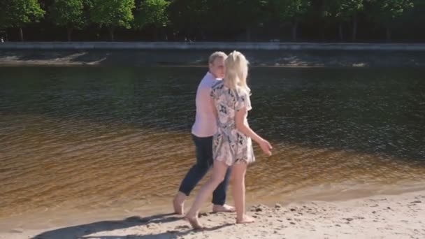 Zeitlupenvideo von einem verliebten Paar, das an einem sonnigen Tag am Fluss spaziert — Stockvideo