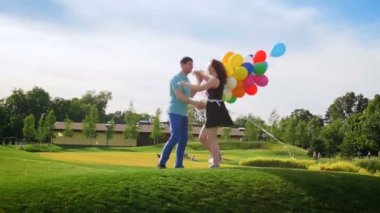 Renkli balonlar Park'ta sarılma grup ile mutlu genç çiftin Slow motion video