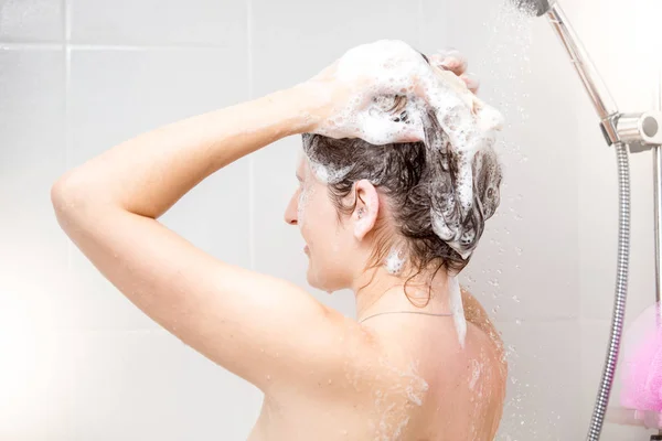 Zadní pohled obraz mladá bruneta žena mytí vlasů šamponem — Stock fotografie