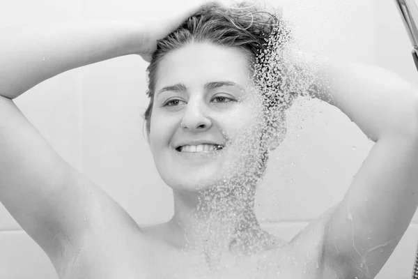 Black and white portrait of beautiful young woman enjoying having shower — Stock Photo, Image