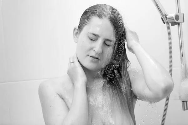 Closeup zwart-wit portret van een jonge vrouw met gesloten ogen permanent onder douche — Stockfoto