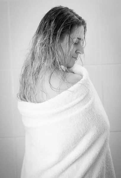 स्नान केल्यानंतर पांढरा टॉवेलमध्ये झाकलेल्या सुंदर तरुण स्त्रीचे काळे आणि पांढरे पोर्ट्रेट — स्टॉक फोटो, इमेज