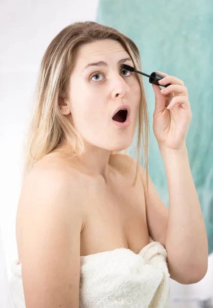 Genç kadın portresi rimel uygulamak ve banyo makyaj yapıyor iken ağız açılır — Stok fotoğraf