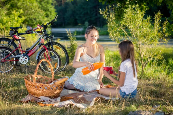 Cute teenage girl having picnic with mother in field at sunset — Stock Photo, Image