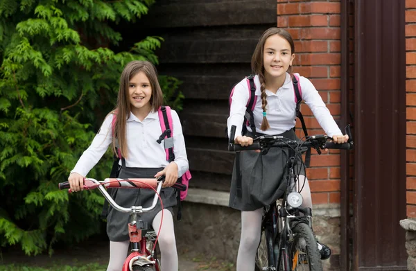 Retrato de dos hermanas en uniforme escolar en bicicleta —  Fotos de Stock