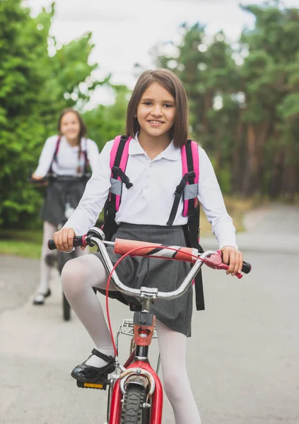 Portret piękna dziewczyna w szkole jednolitego i torby jazda do szkoły na rowerze — Zdjęcie stockowe