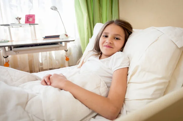 Портрет усміхненої брюнетки дівчини-підлітка, що лежить у спальні — стокове фото