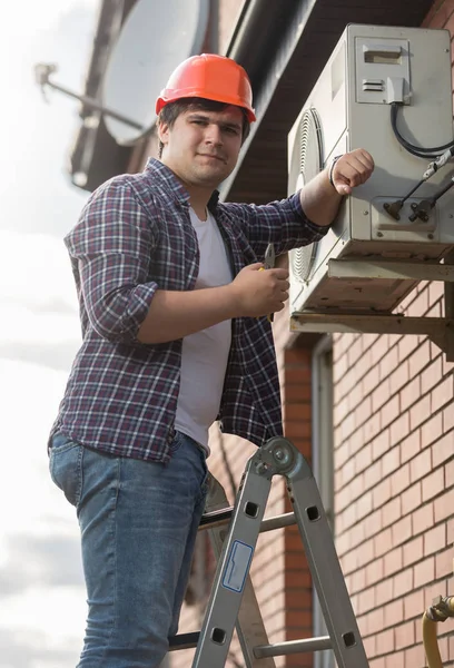 Portrait of smiling male repairman repairing air conditioner system — Stock Photo, Image