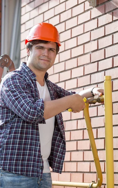 Porträtt av leende manliga ingenjör arbetar och åtgärda rören — Stockfoto