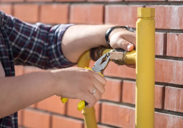 Foto de primer plano del ingeniero masculino que fija la válvula de presión en los tubos amarillos —  Fotos de Stock