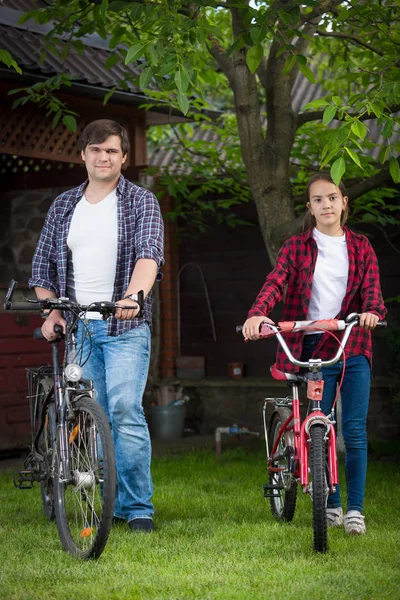 Genç adam ve genç kız Bisiklet Evi arka bahçe ile poz gülümseyen — Stok fotoğraf