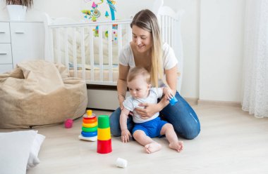 Beauitufl genç kadın katta yatak odası, yürümeye başlayan çocuk oğlu ile oynamak