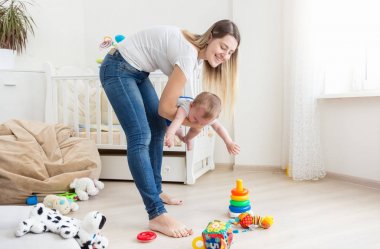 Onun ağlayan 10 aylık erkek bebek tutan genç anne