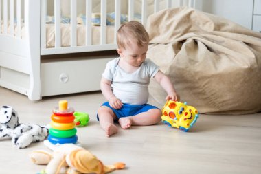 10 aylık yürümeye başlayan çocuk yatak odası katında renkli oyuncaklar ile oynama