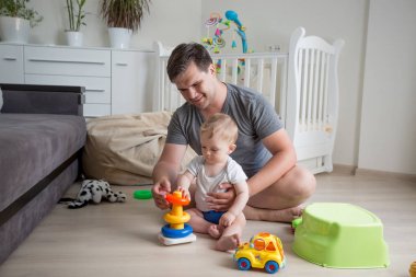 Onun bebek çocuk oyuncak kule inşa eğitmektir mutlu gülümseyen adam