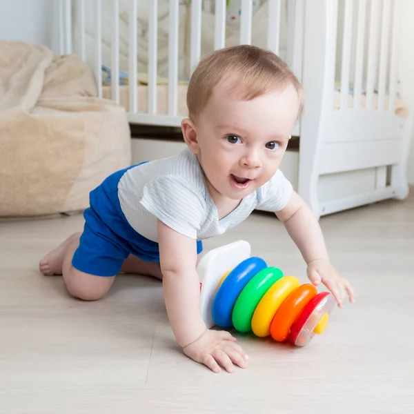 Cute 10 months old toddler boy crawling on floor and looking in camera — Stock Photo, Image