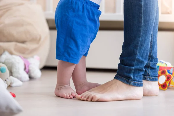 Close up imagem de 10 meses de idade bebê meninos pés de pé com a mãe — Fotografia de Stock