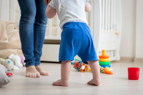 Крупный план 10-месячного мальчика, делающего первые шаги домой к матери — стоковое фото