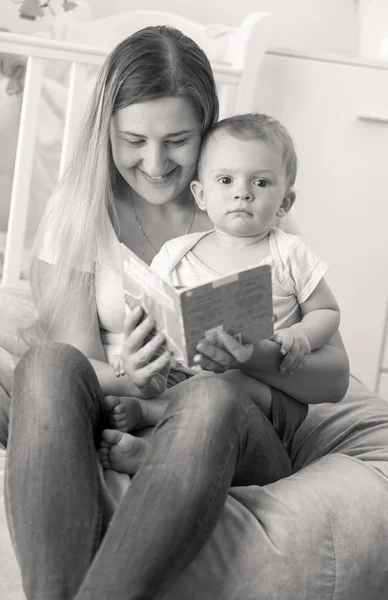 Preto e branco retrato de jovem mãe lendo história para seu bebê menino — Fotografia de Stock