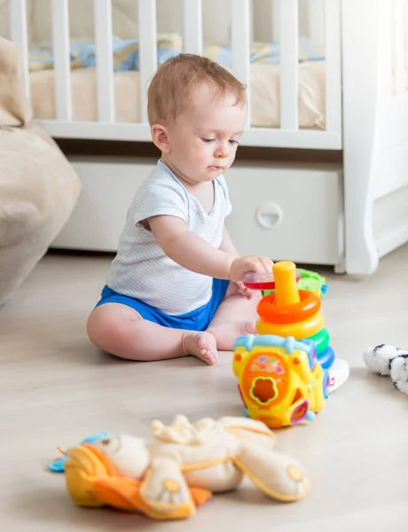 10 meses de idade menino brincando com brinquedos educativos no chão no quarto — Fotografia de Stock