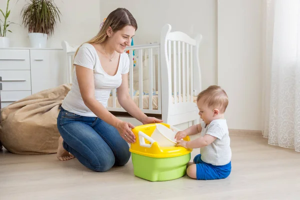 美しい若い母親は赤ちゃん鍋を使用して彼女の 10 ヶ月の息子を教える — ストック写真