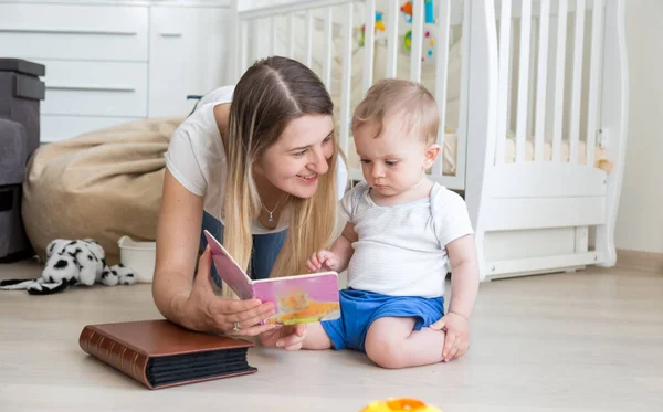Adorável criança menino sentado no chão com a mãe e livro de leitura — Fotografia de Stock