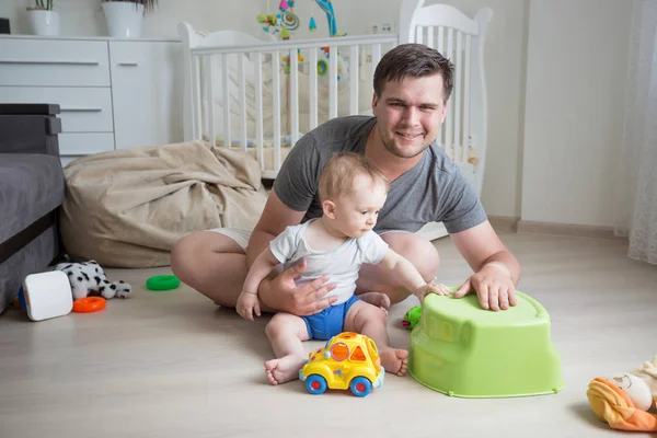 Szczęśliwy ojciec młodych, grając z jego syn dziecko na piętrze w sypialni — Zdjęcie stockowe