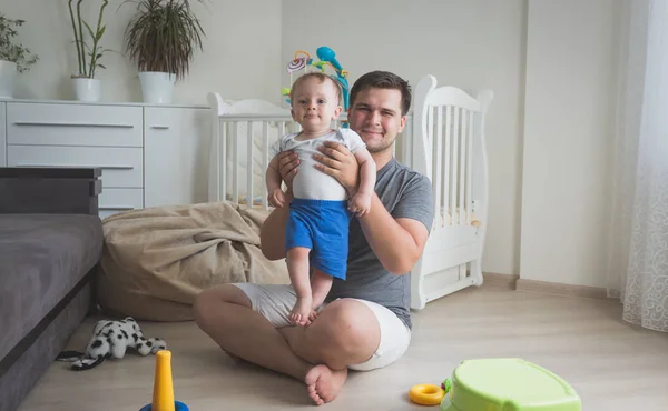 Tónovaný fotografie šťastný s úsměvem otec držel jeho syn 10 měsíců staré dítě — Stock fotografie