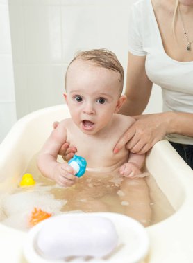 Genç anne bebek oğlu küçük plastik banyo yıkama