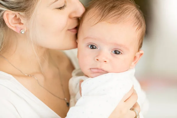 Closup portrait of young woman kissing her 3 months old baby boy — Stock Photo, Image