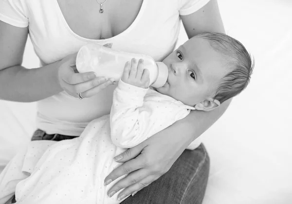 Retrato preto e branco de adorável menino bebendo leite de mamadeira — Fotografia de Stock
