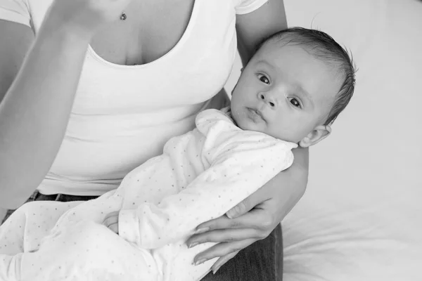 Preto e branco retrato de bonito bebê menino deitado no mães colo e olhando no câmara — Fotografia de Stock