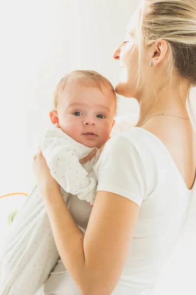 Retrato tonificado de una joven madre abrazando a su pequeño bebé — Foto de Stock