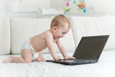 Şirin Bebek bezli laptop doğru yatağa sürünerek