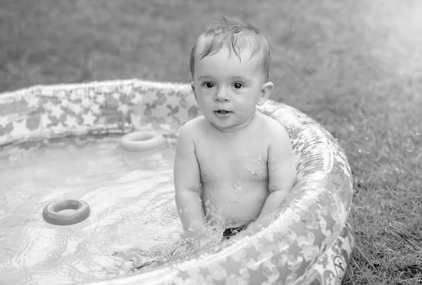 Retrato en blanco y negro del adorable niño de 10 meses jugando en la piscina inflable — Foto de Stock