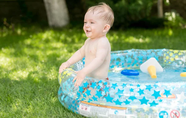 Buon bambino ridente che salta nella piscina gonfiabile nel cortile — Foto Stock