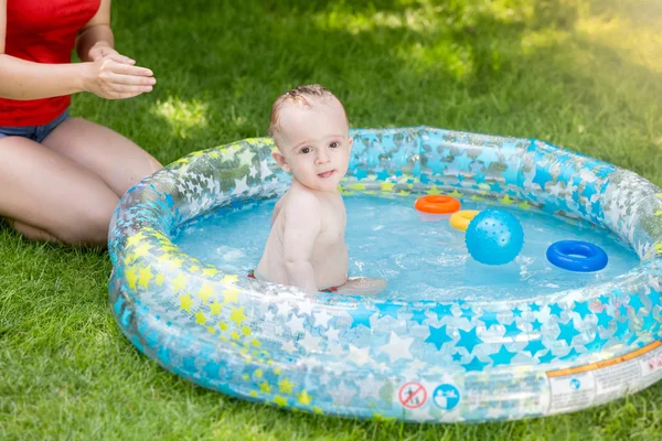 Retrato de lindo niño jugando con juguetes en piscina inflable — Foto de Stock