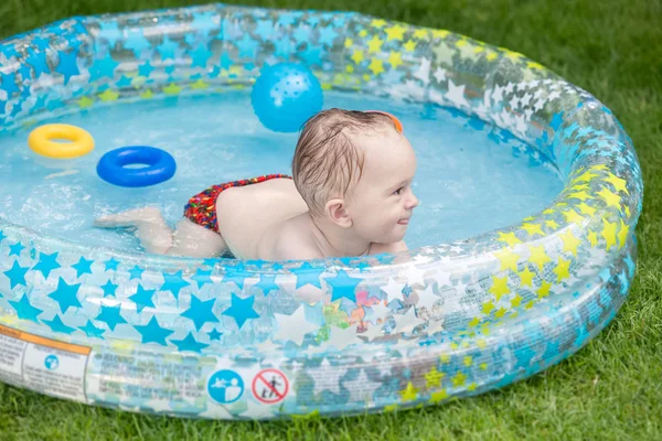 Retrato de sorrindo 1 ano menino do bebê de olf nadando na piscina inflável no quintal da casa — Fotografia de Stock