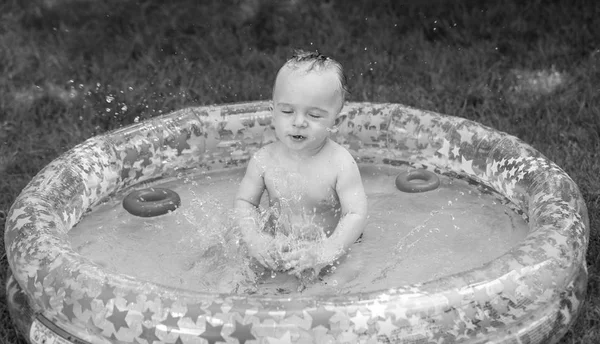 Czarno-biały portret szczęśliwy toddler wesoły chłopiec zalewaniem w nadmuchiwany basen — Zdjęcie stockowe