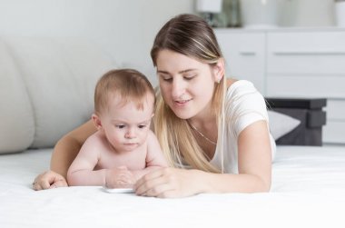 Annemle yatakta yatarken ve çizgi film tablet bilgisayarda izlemek çok güzel bebek çocuk portresi