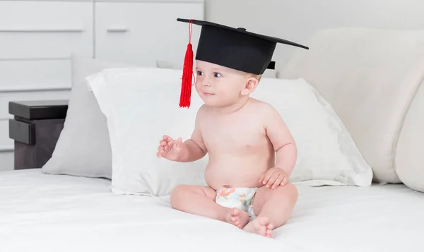 Carino 10 mesi bambino ragazzo in pannolini indossando cappello graduazione con tessuto rosso — Foto Stock