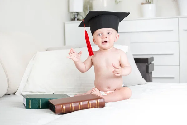 Sorrindo menino em chapéu de formatura preto olhando na câmera — Fotografia de Stock