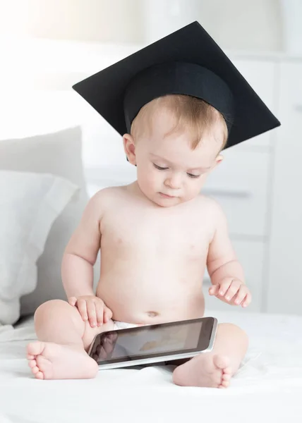 Retrato de bebé lindo en pañales y sombrero de graduación usando tableta digital. Concepto de niños inteligentes y educación temprana con el uso de tecnologías modernas y computadoras —  Fotos de Stock