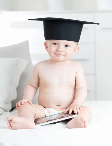 Glücklich lächelnder kleiner Junge mit Uniferity-Abschlussmütze blickt in die Kamera — Stockfoto