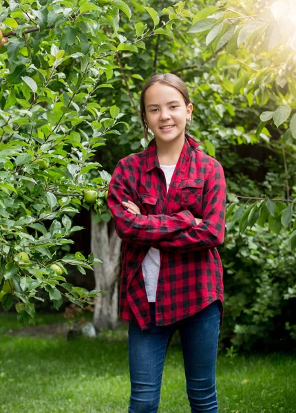 Portrait of smiling teenage girl in red checkered shirt posing at oprchard — Stock Photo, Image