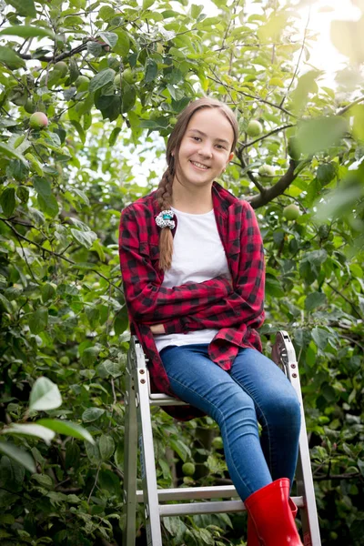 Retrato de sorrir menina adolescente feliz sentado em cima da escada rolante no jardim — Fotografia de Stock