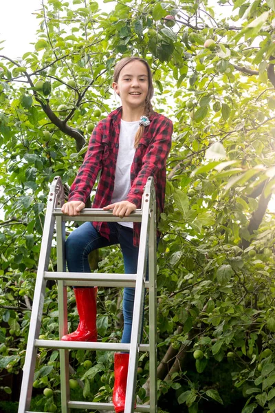 Portrait d'adolescente souriante sur un escabeau une torchard — Photo