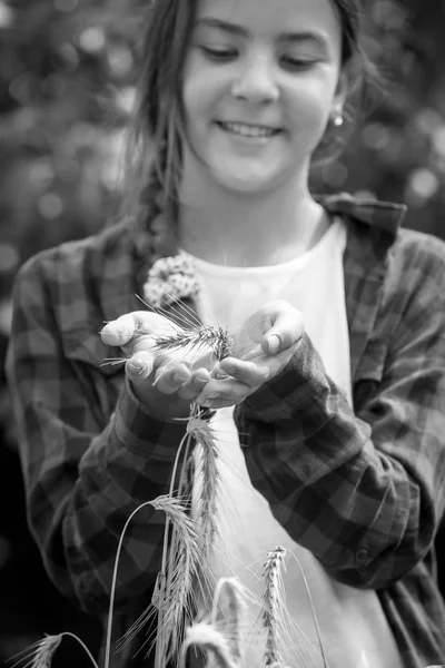 Black and white closeup image of smiling teenage girl holding ripe white in hands — Stock Photo, Image